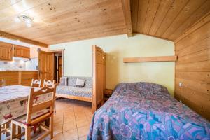 een slaapkamer met een bed en een tafel en stoelen bij Apt Chénives 1 - Morzine in Morzine