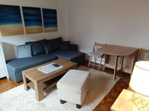 a living room with a blue couch and a table at GRBAVICA COZY APARTMENT in Sarajevo