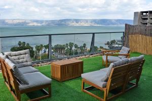 Un balcón con sillas y vistas al océano. en Levication 3 bedroom lakefront en Tiberias