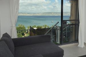 a living room with a couch and a view of the ocean at Levication 3 bedroom lakefront in Tiberias