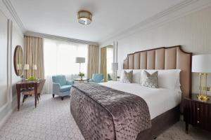 um quarto de hotel com uma cama grande e uma secretária em The Westbury Hotel em Dublin