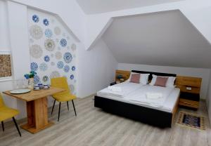 Schlafzimmer mit einem Bett, einem Tisch und Stühlen in der Unterkunft ORI Blue Studio Malul Muresului in Arad