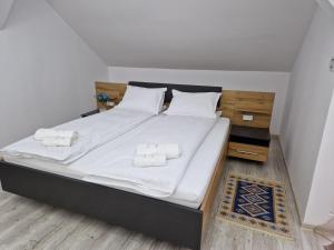 ein Schlafzimmer mit einem großen Bett mit weißer Bettwäsche und Kissen in der Unterkunft ORI Blue Studio Malul Muresului in Arad