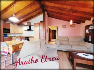 a living room with white couches and a table at Araiko Etxea Casa Rural in Tuyo