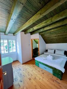 a bedroom with a large bed with a wooden ceiling at Cabanita in Întorsura Buzăului