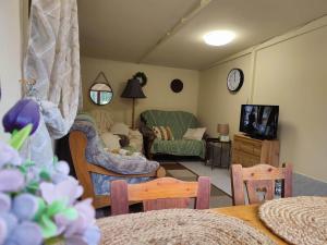 a living room with a couch and a tv at Királyos Pihenőház in Háromhuta