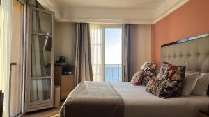 a bedroom with a bed with a large window at Hôtel Des Gouverneurs in Bastia