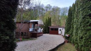 a house with a garage between two large trees at Királyos Pihenőház in Háromhuta