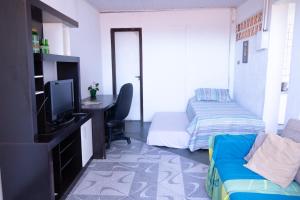 uma sala de estar com uma televisão e uma cama em Apartamentos na região Central Cobertura e 2 quartos em Ponta Grossa
