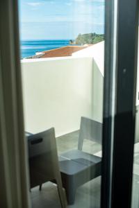 a room with a chair and a view of the ocean at Olive Boutique Guesthouse in Vila Franca do Campo