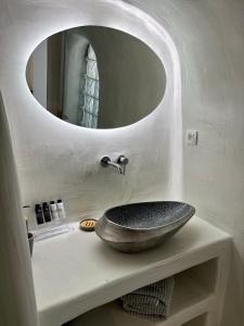 a bathroom with a stone sink and a mirror at Aidos Villa Santorini in Megalokhori