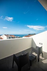 een balkon met 2 stoelen en uitzicht op de oceaan bij Olive Boutique Guesthouse in Vila Franca do Campo