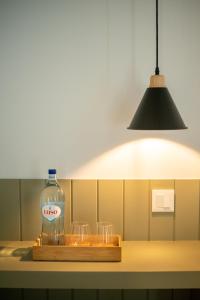 a bottle of water on a wooden tray with glasses at Olive Boutique Guesthouse in Vila Franca do Campo
