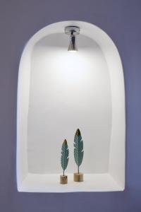 two plants on a white shelf with a light at Aidos Villa Santorini in Megalokhori