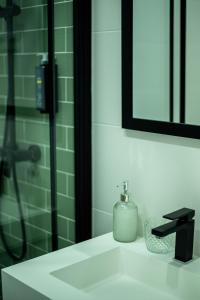 a bathroom with a sink with a shower and a mirror at Olive Boutique Guesthouse in Vila Franca do Campo