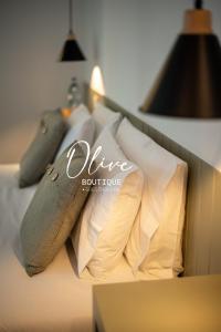 a pile of pillows sitting on a bed at Olive Boutique Guesthouse in Vila Franca do Campo