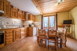 a kitchen with wooden cabinets and a table and chairs at Apt Chénives 2 - Morzine in Morzine