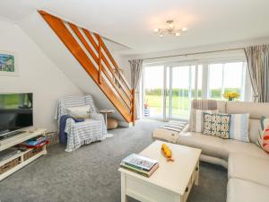 a living room with a couch and a tv at Gull Cottage in Lowestoft