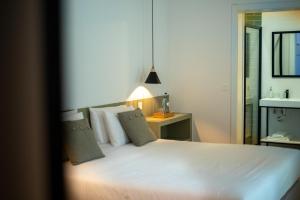 a bedroom with a large white bed and a table at Olive Boutique Guesthouse in Vila Franca do Campo