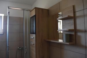 a bathroom with a shower and a wooden cabinet at Apartmani Tomljenović in Senj +47 photos