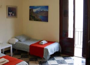 a bedroom with two twin beds and a window at Hostal Atlanta in El Arenal
