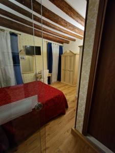 Schlafzimmer mit einem roten Bett und einer Glastür in der Unterkunft Hotel Tintoretto in Venedig