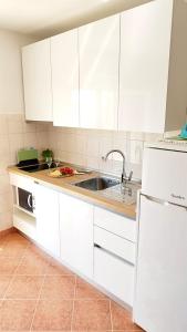 una cucina con armadi bianchi e lavandino di Apartment Anita a Trogir