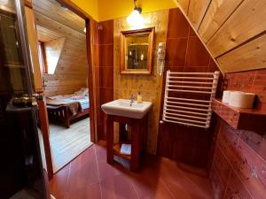 a bathroom with a sink and a bedroom at POD ROŻKAMI in Cisna