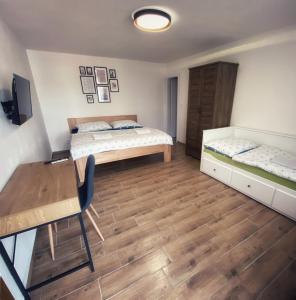 1 dormitorio con 2 camas, mesa y escritorio en R-Penzion, en Český Krumlov