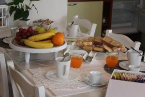 Le Trame di Ka.Sa في بورتو أوتيولو: طاولة مع صحن من الفواكه وعصير البرتقال