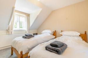 سرير أو أسرّة في غرفة في Elvington Cottage - Family-friendly cheerful house at the heart of the Cotswolds