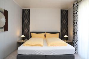 1 dormitorio con 1 cama con 2 lámparas en 2 mesas en Ferienwohnungen Sonnleite, en Friedenfels