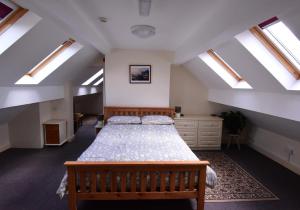a attic bedroom with a bed and skylights at Station Cottage in Kirkby Stephen