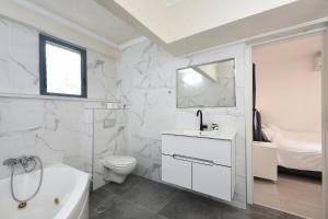 baño blanco con lavamanos y aseo en Levication 3 bedroom lakefront en Tiberias