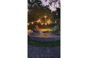 a group of chairs sitting in a backyard at night at OYO Pousada Coisa Mais Linda in Iguape