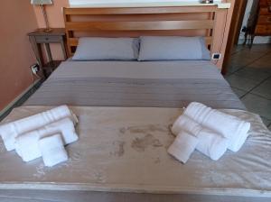 uma cama com três rolos de toalhas em Appartamento con incantevole vista mare em Livorno