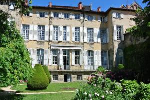 une maison ancienne avec un jardin en face dans l'établissement Maison d'hôtes - Hôtel particulier de Jerphanion Cambacérès, au Puy-en-Velay