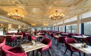 a dining room with tables and chairs and chandeliers at PLAZA Premium Timmendorfer Strand in Timmendorfer Strand