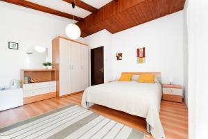 a bedroom with a white bed and wooden ceilings at Studio and Room Tea in Rovinj