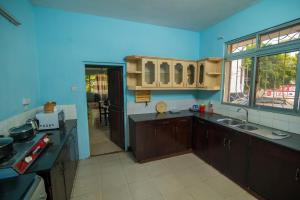 una cocina con armarios marrones y una pared azul en 3 bedroom Apartment en Dar es Salaam