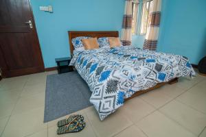 1 dormitorio con 1 cama y un par de zapatos en el suelo en 3 bedroom Apartment en Dar es Salaam