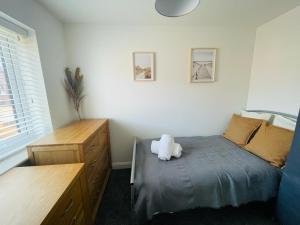 a bedroom with a bed with a stuffed animal on it at Barry Waterfront Stays - ENTIRE 3 BED PROPERTY in Barry