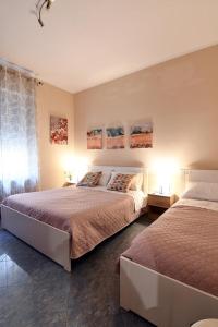 1 dormitorio con 2 camas y ventana en Affitti turistici: OASI FELICE, en Torrile