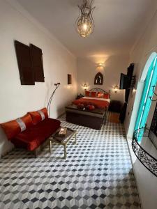 1 dormitorio con cama, sofá y mesa en Riad 1001 couleurs en Marrakech