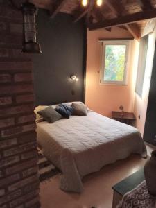1 dormitorio con cama y ventana en Cabaña Los Ulmos Bariloche en San Carlos de Bariloche
