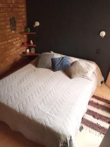 1 cama blanca con almohadas en el dormitorio en Cabaña Los Ulmos Bariloche en San Carlos de Bariloche