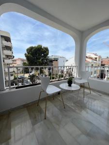 uma varanda com 2 cadeiras, uma mesa e uma janela em Apartamento Puerto Banus em Marbella