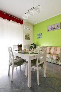 una mesa blanca y sillas en una habitación con sofá en Affitti turistici: OASI FELICE, en Torrile