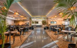 um restaurante com mesas e cadeiras e um bar em Brown Red Sea - Central Park em Eilat