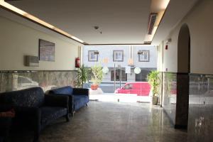 un vestíbulo con dos sofás azules y un coche rojo en Altamyoiz Sirved Apartments en Yeda